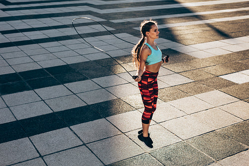 Sportswoman skipping ropes outdoors