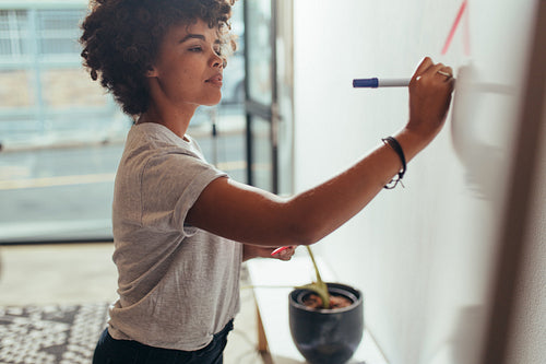 Woman writing her ideas on white board