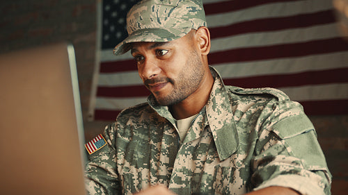 Calling home from the military, patriotic soldier having a video chat with his family online