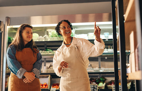Grocery store supervisor giving instructions to her new employee in a shop