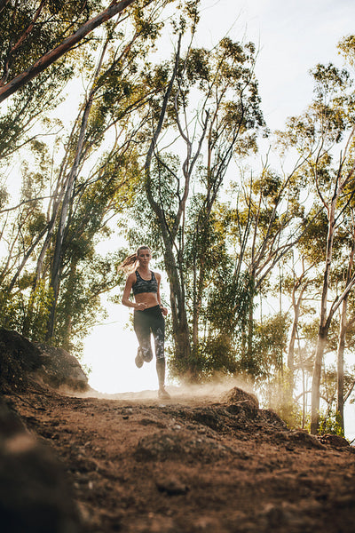 Sporty woman running on country trail