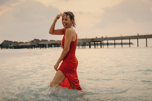 Beautiful mature woman in a luxurious gown enjoying a vacation by the ocean