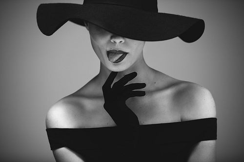 Woman in retro look sticking out tongue