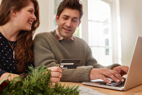 Couple shopping online at home for Christmas
