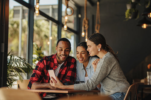 Woman sharing pictures with friends at cafe