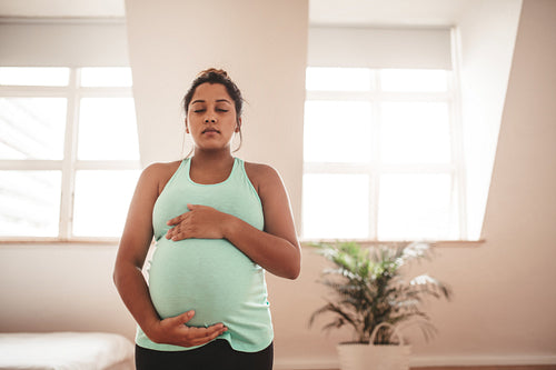 Pregnant woman meditating at home