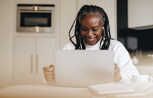 Cheerful businesswoman having a video call in her home office