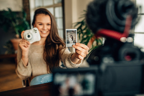 Female blogger showing an instant photograph picture
