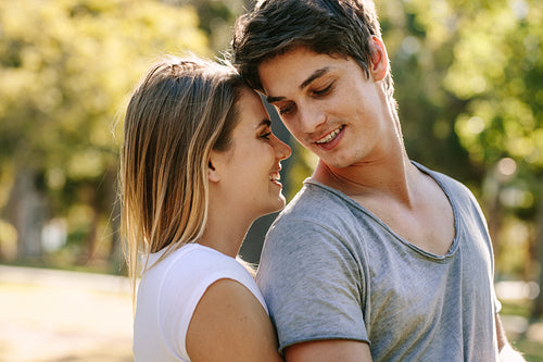 Happy couple standing in park together
