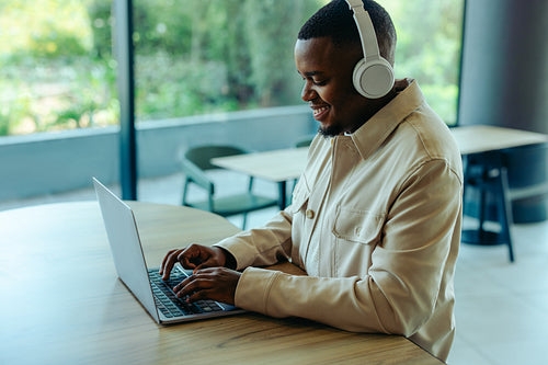 Businessman working remotely as a digital nomad with headphones