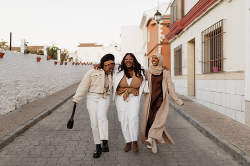 Joyful girlfriends laughing together outdoors