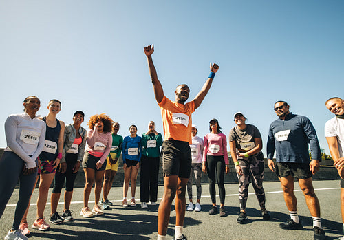 Group of marathon runners celebrating at the finish line