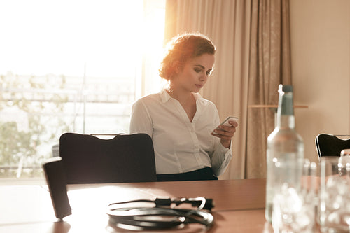 Businesswoman at conference table using mobile phone