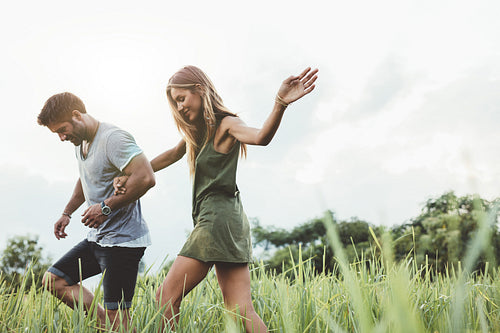 Young couple walking through meadow 