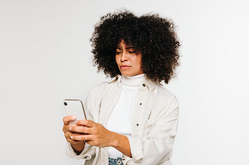 Young woman using a smartphone against a white background