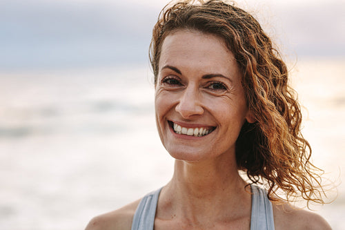 Portrait of a fitness woman standing at the beach
