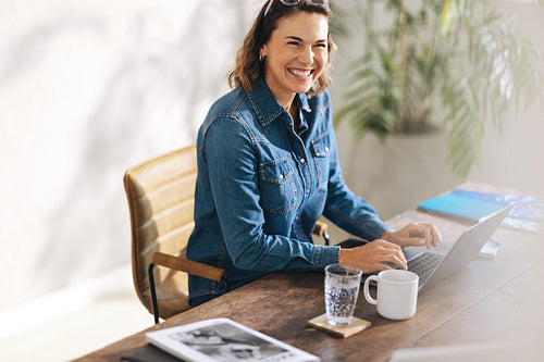 Businesswoman smiling while working on a laptop in the office