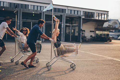 Young friends racing with shopping carts