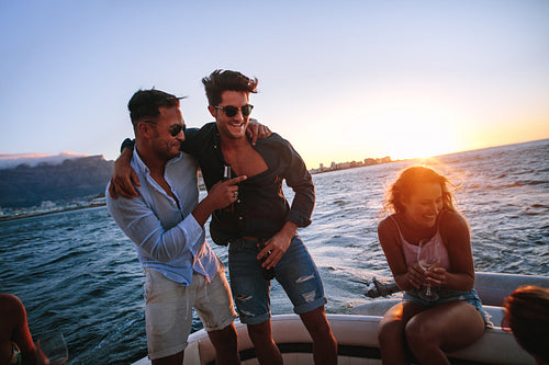 Friends enjoying in a sunset boat party