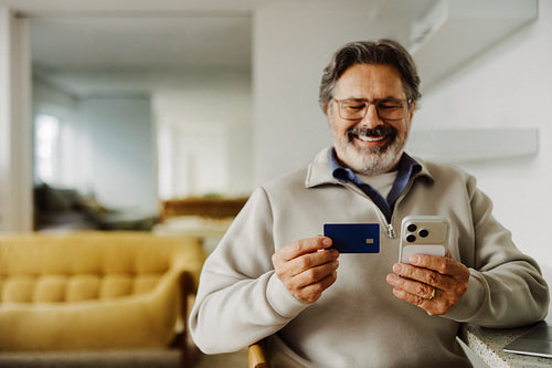 Shopping senior man uses a smartphone for mobile payment