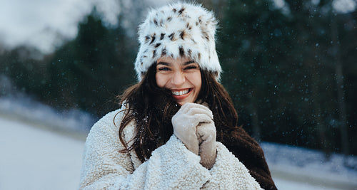 Smiling brunette woman poses outdoors in winter snow