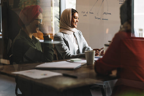 Cheerful Muslim businesswomen having an online meeting in an off