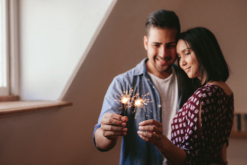 Beautiful young couple celebrating with sparklers