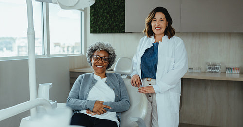 Smiling dentist and senior patient in bright dental office