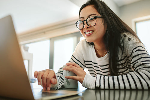 Asian woman using laptop at home