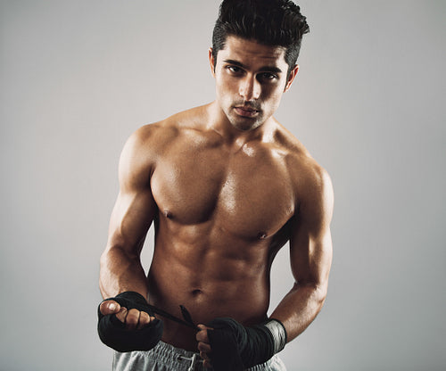 Tough young male athlete on grey background