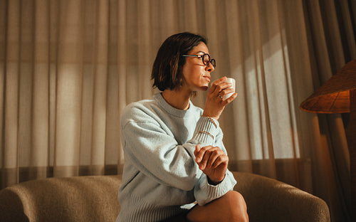 Seated woman sips coffee during work in a private office workspace