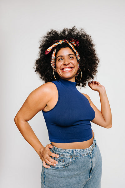 Young woman with curly hair smiling happily in a studio
