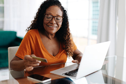 Electronic banking for senior citizens: Elderly woman using her credit card online