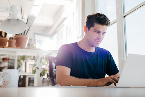 Young businessman using laptop in office