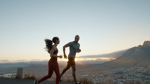 Couple on a morning run on the hillside road