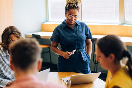 Young businesswoman leading discussion with colleagues in office meeting