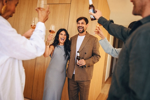 Happy couple celebrating with friends at a cheerful home gathering