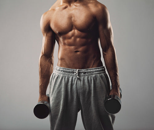 Muscular young man working out with weights