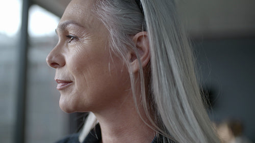 Senior business woman looking outside window