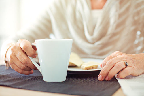 Wrinkled Hands with a Cup of Coffee