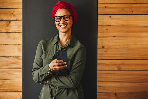 Happy female entrepreneur using a smartphone in an office