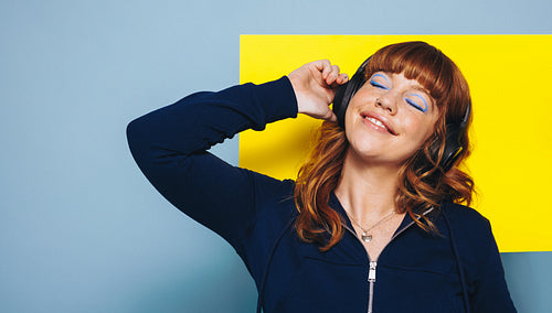 Woman listening to music on headphones in a studio