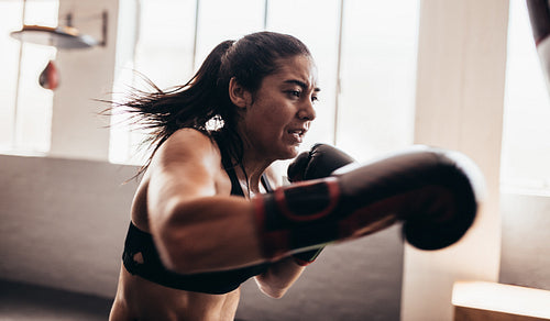 Female boxer training inside a boxing ring