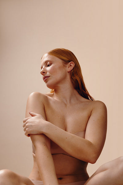 Wellness portrait of woman embracing her bare skin
