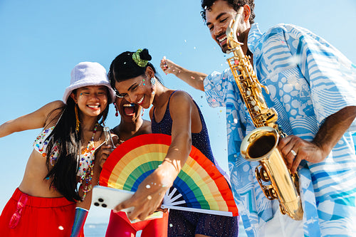 Friends celebrating at beach carnival with music