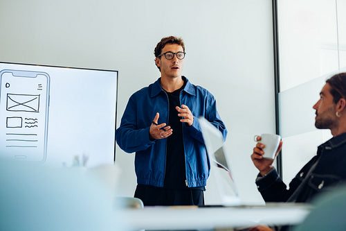 Male UX designer presenting mobile app concepts to team