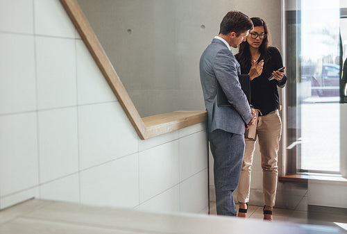 business associates discussing work in office stairway