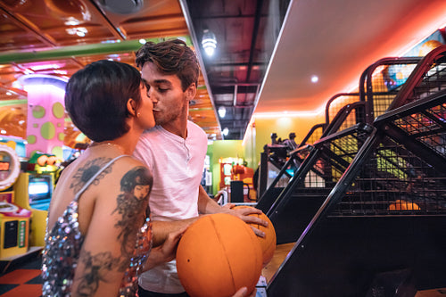 Romantic couple kissing at a gaming arcade