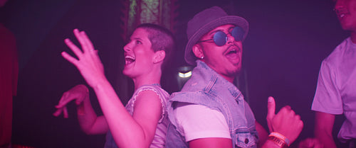 Friends dance together and celebrate at a music festival