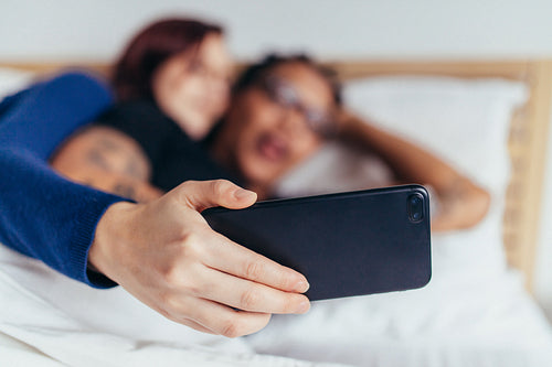 Couple taking selfie in bed